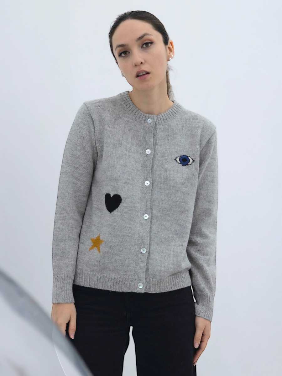 grey button up cardigan decorated with a turkish eye, black heart and a yellow star, worn by a model on plain background
