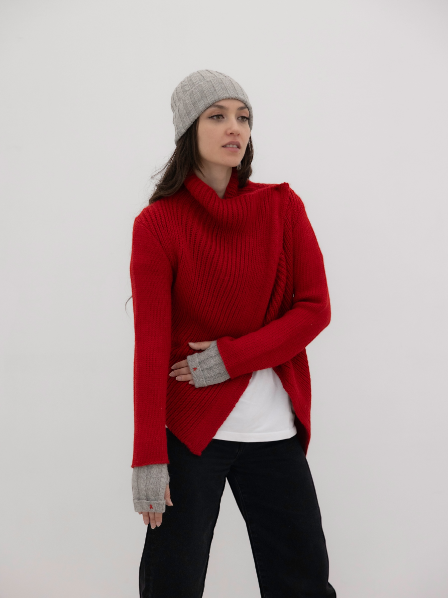 chunky red alpaca knitted cardigan with unique crossed design, worn by a model styled with grey yapa beanie and fingerless grey gloves