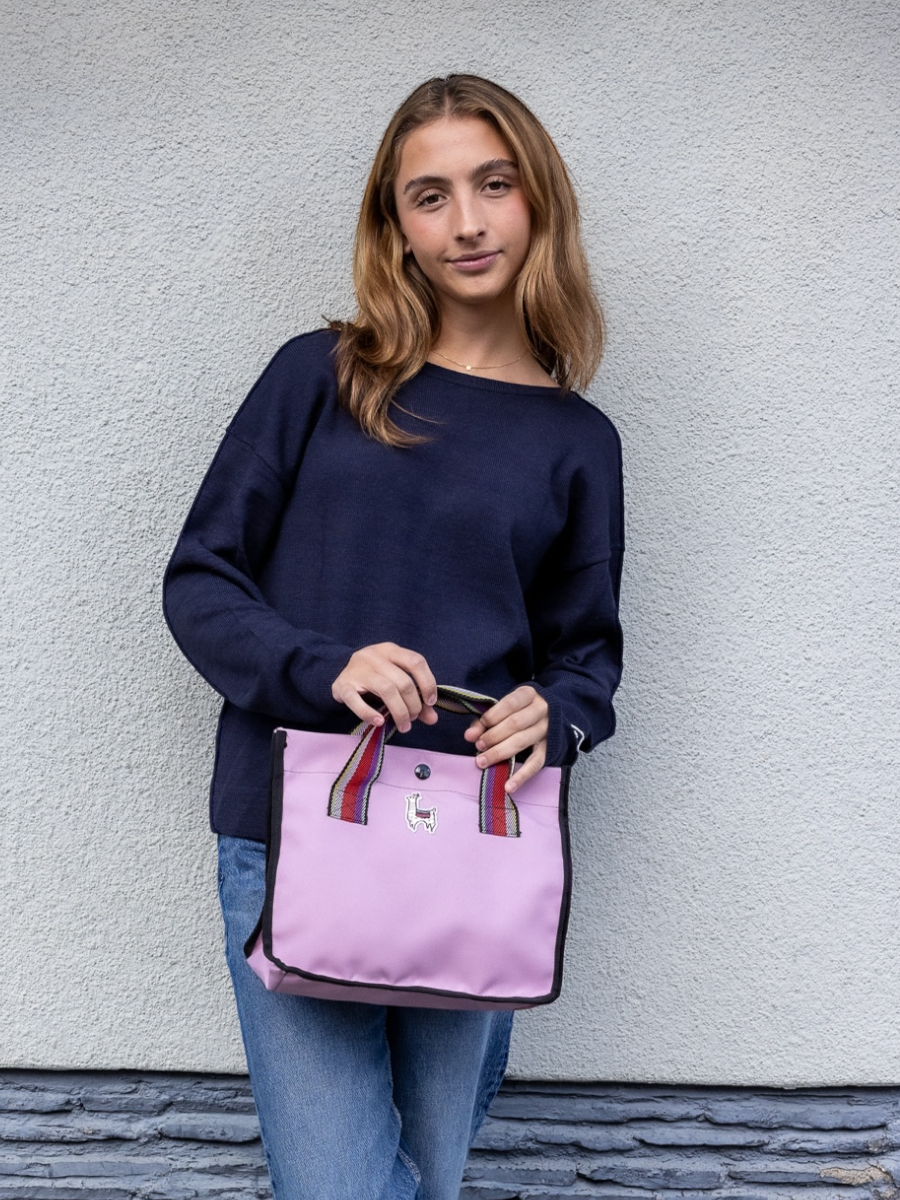 Navy blue alpaca sweater featuring a small embroidered heart on the sleeve, shown here on a model against a plain background. This reversible design can be worn as a V-neck on one side or flipped to a classic round neck on the other, offering two looks in one piece.