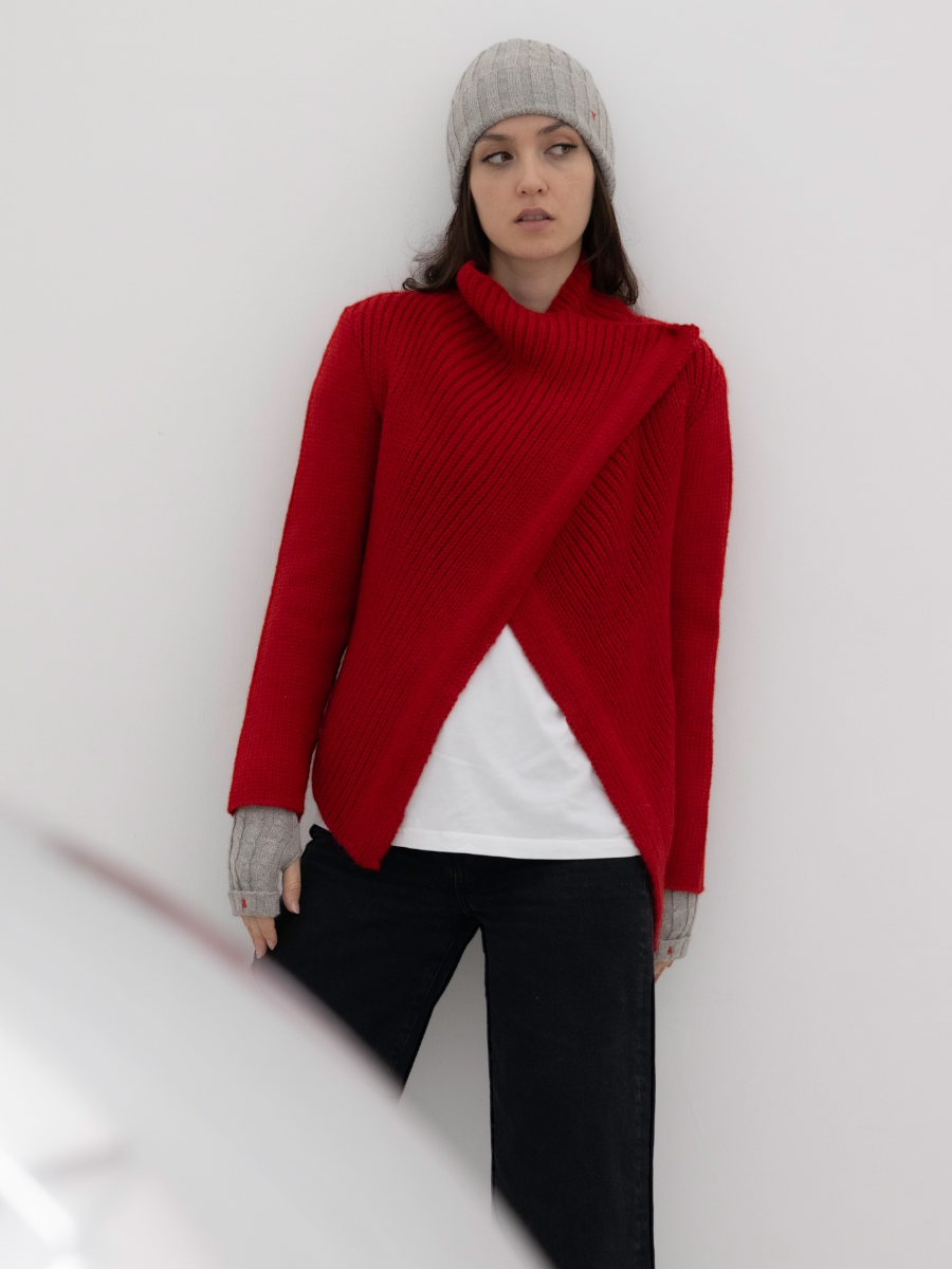chunky red alpaca knitted cardigan with unique crossed design, worn by a model styled with grey yapa beanie and fingerless grey gloves