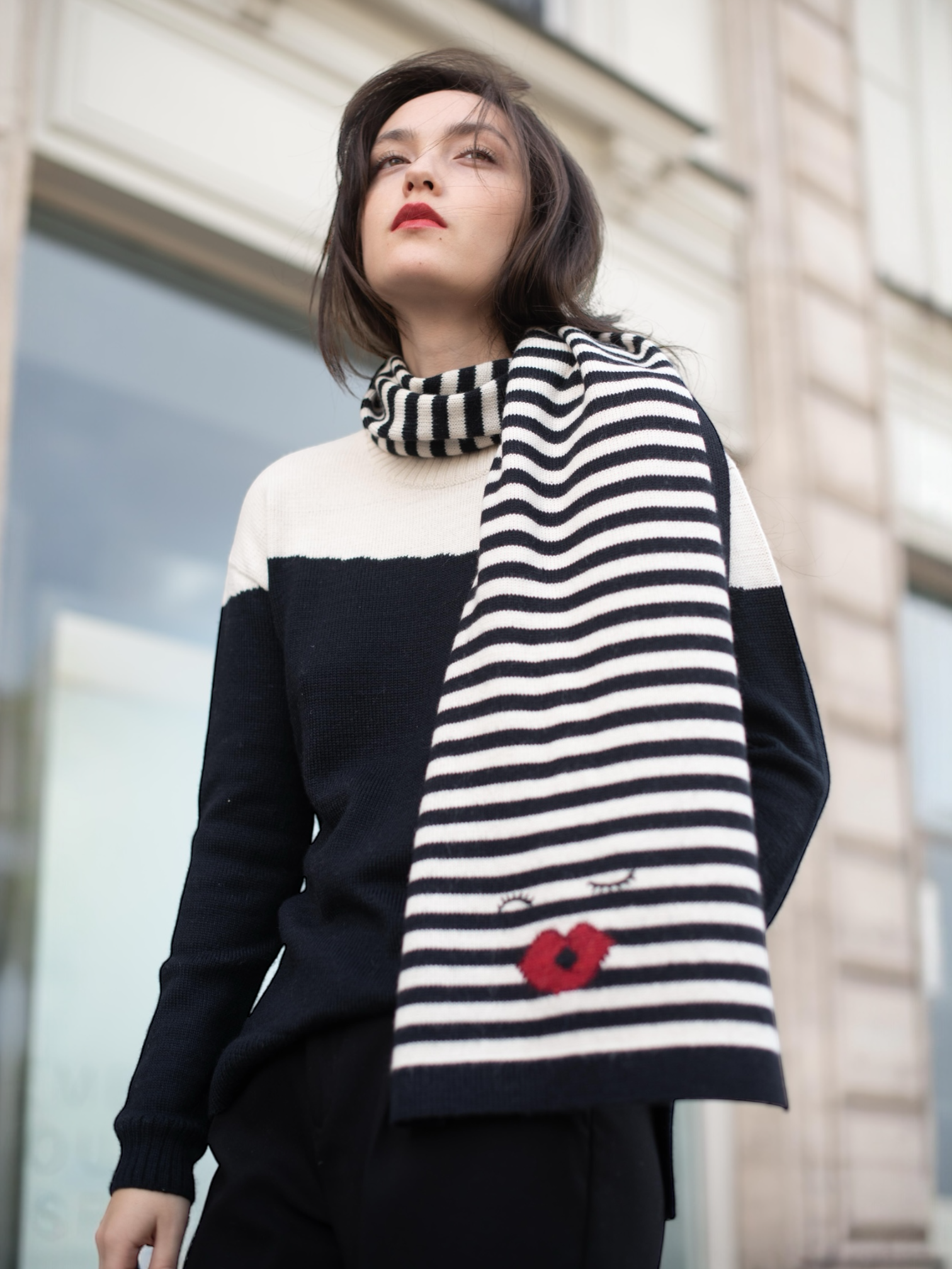 Mia zebra alpaca wool stripped scarf with a kiss design on a model wearing a black and whit color clock sweater