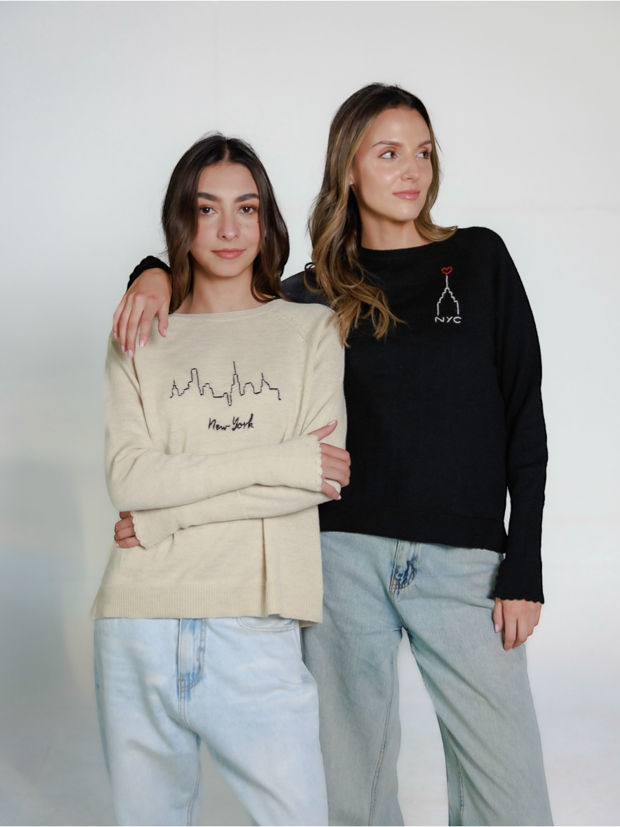  two models wearing New York design sweaters hand embroidered over a white background