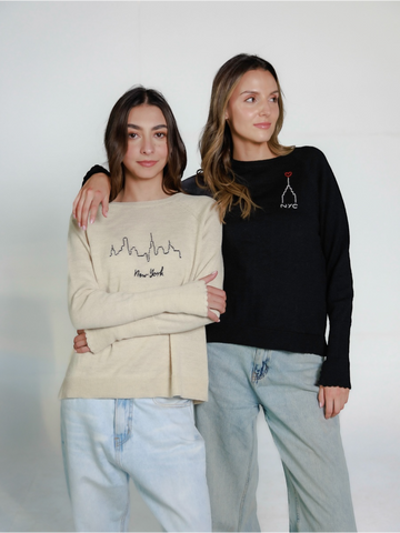  two models wearing New York design sweaters hand embroidered over a white background