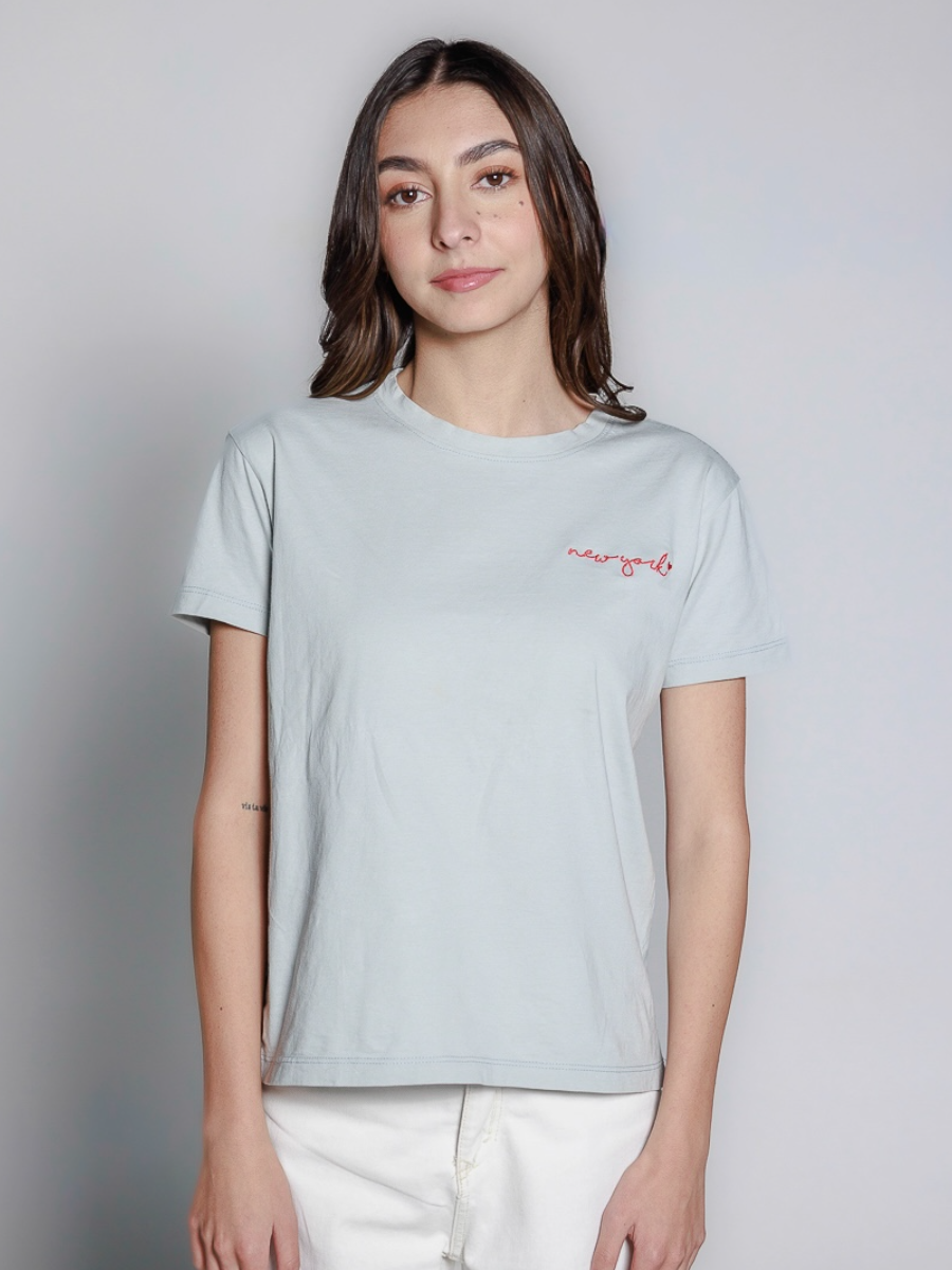 Aqua cotton t-shirt featuring a small red “new york” embroidery on the chest, worn by a model in plain background