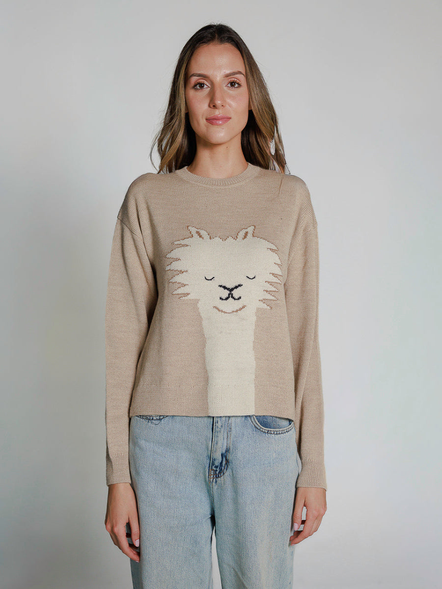 Beige alpaca knitted sweater featuring a playful alpaca face design on the front, worn by a model on a white background.
