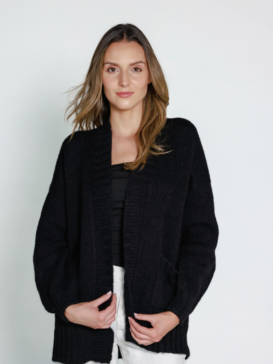Black alpaca cardigan featuring worn by a model in a white background