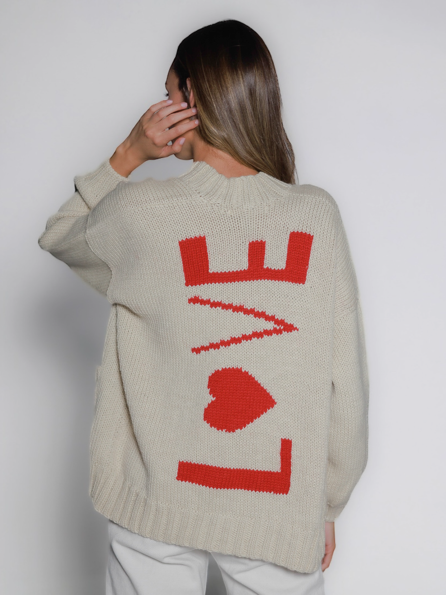 Person wearing a white sweater with red 'LOVE' design on the back against a white background