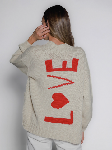 Person wearing a white sweater with red 'LOVE' design on the back against a white background