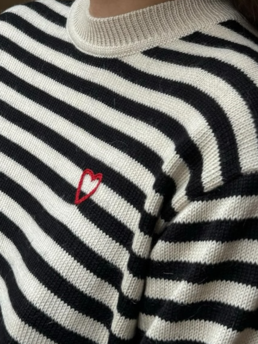 black and white stripped alpaca sweater with a red heart detail on a model