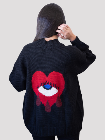 Person wearing a black sweater with a red heart design on the back against a light gray background