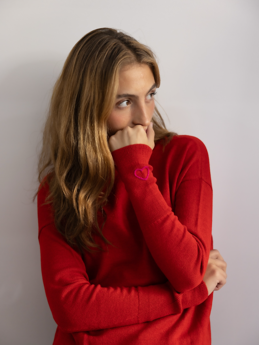 red Alpaca Basic V neck sweater with a hand embroidered heart in the sleeve.