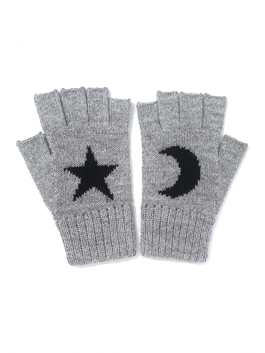 Woman wearing a grey knitted gloves with a design of a black star and a moon 