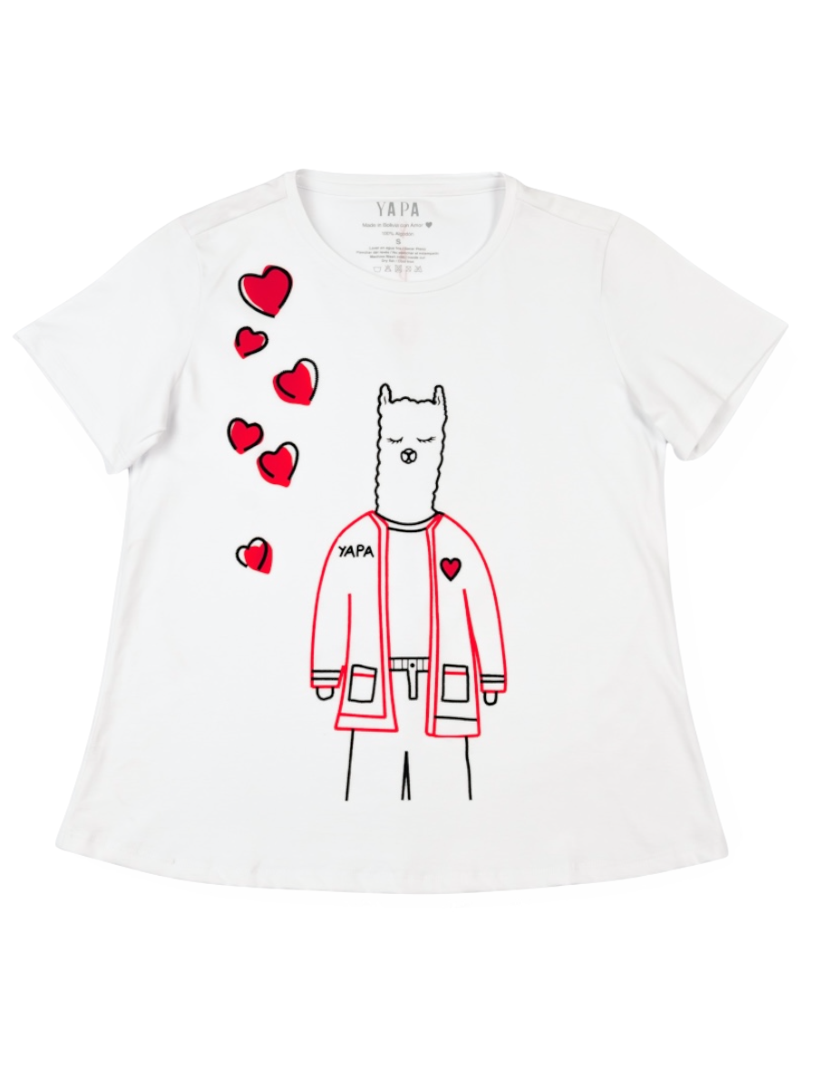 White cotton t-shirt featuring a playful embroidered alpaca in a red jacket with scattered red heart motifs and the word “YAPA” 