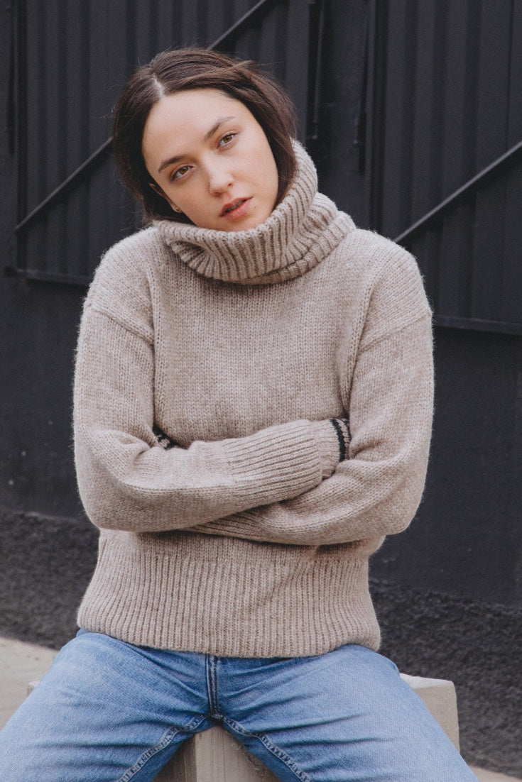 Knitted neck warmer with a 'Yapa' label on a white background