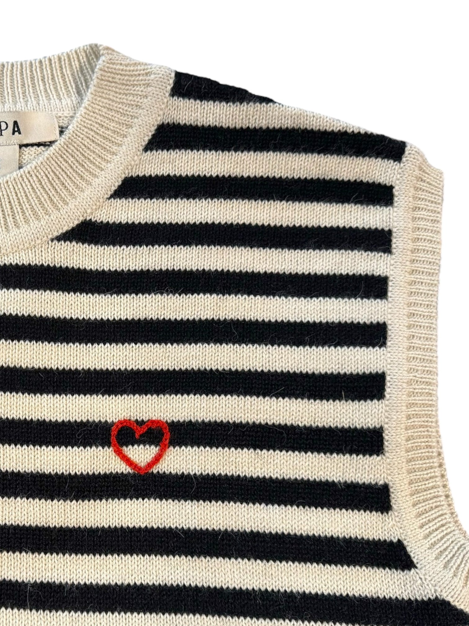 Black and white striped sweater with a red heart emblem on a white background
