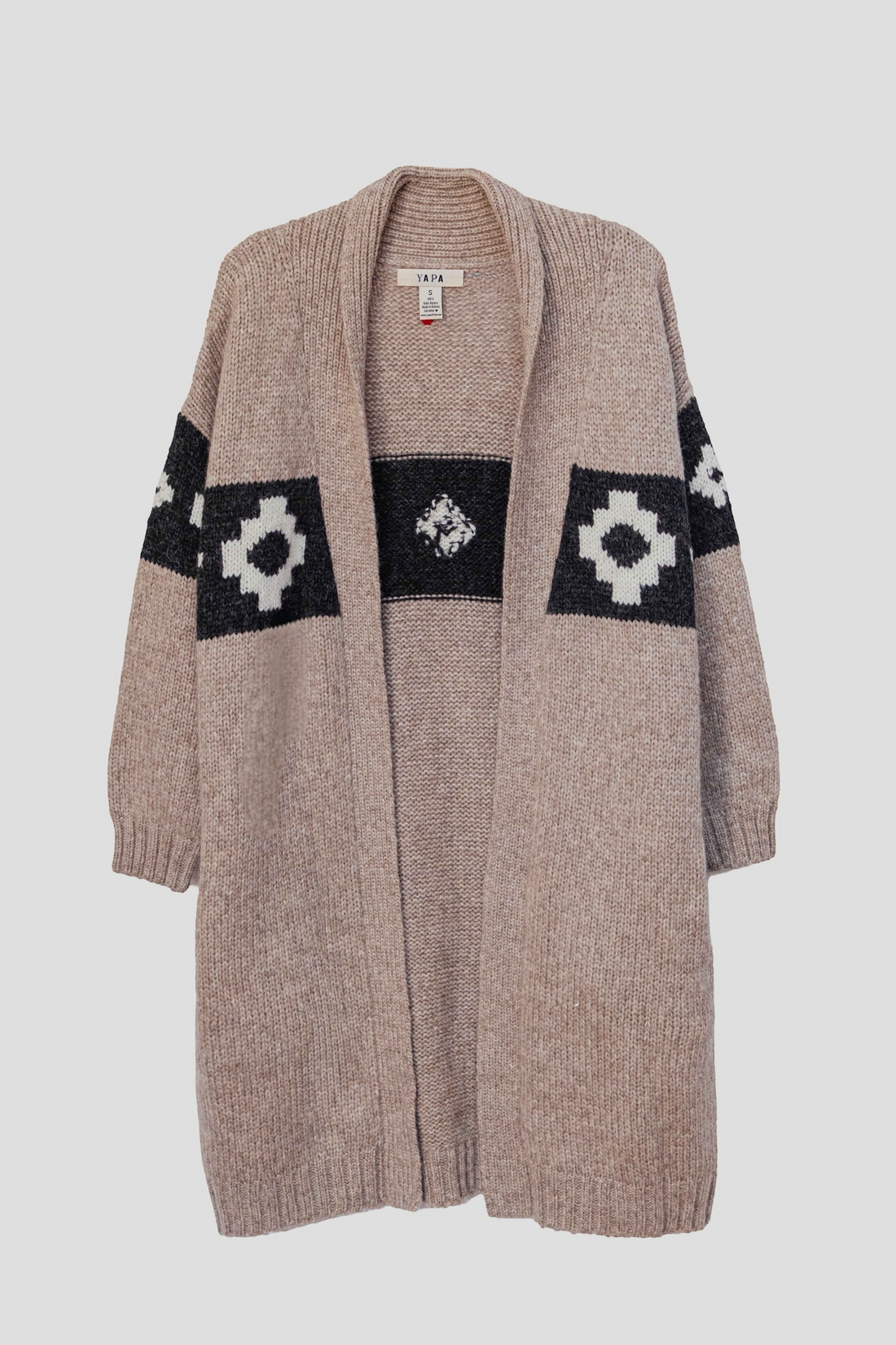 A beige knit cardigan sweater with black and white geometric patterns across the chest and sleeves, shown against a light gray background.