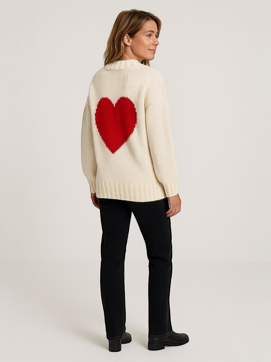 Woman wearing a black knitted cardigan with a red heart in the back walking around New York City