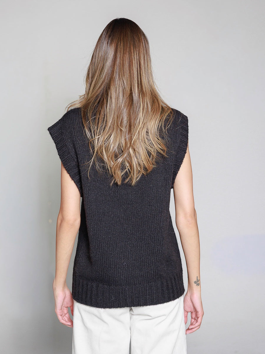 model wearing a black alpaca knitted vest against a plain background