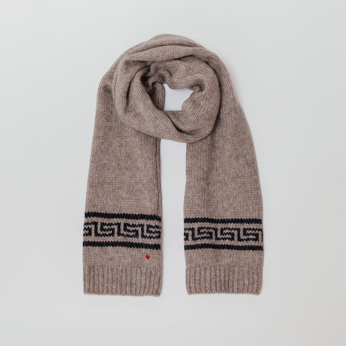 Brown knitted scarf with a patterned edge on a light gray background