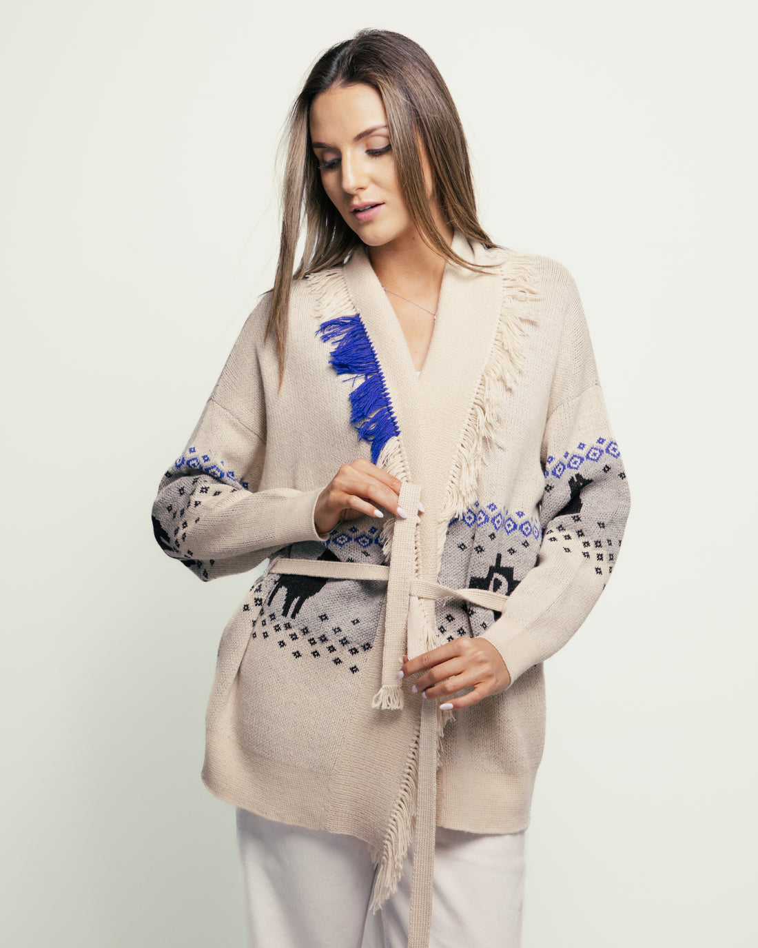 Woman wearing a patterned cardigan with a white background