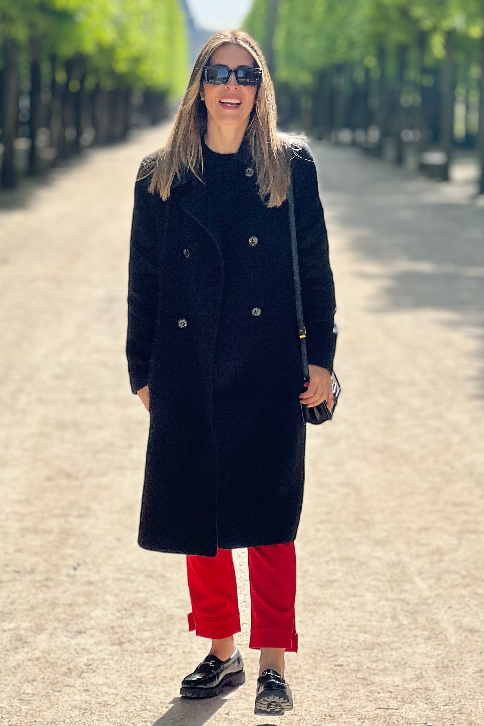 model wearing a black alpaca  coat double button long with city view background