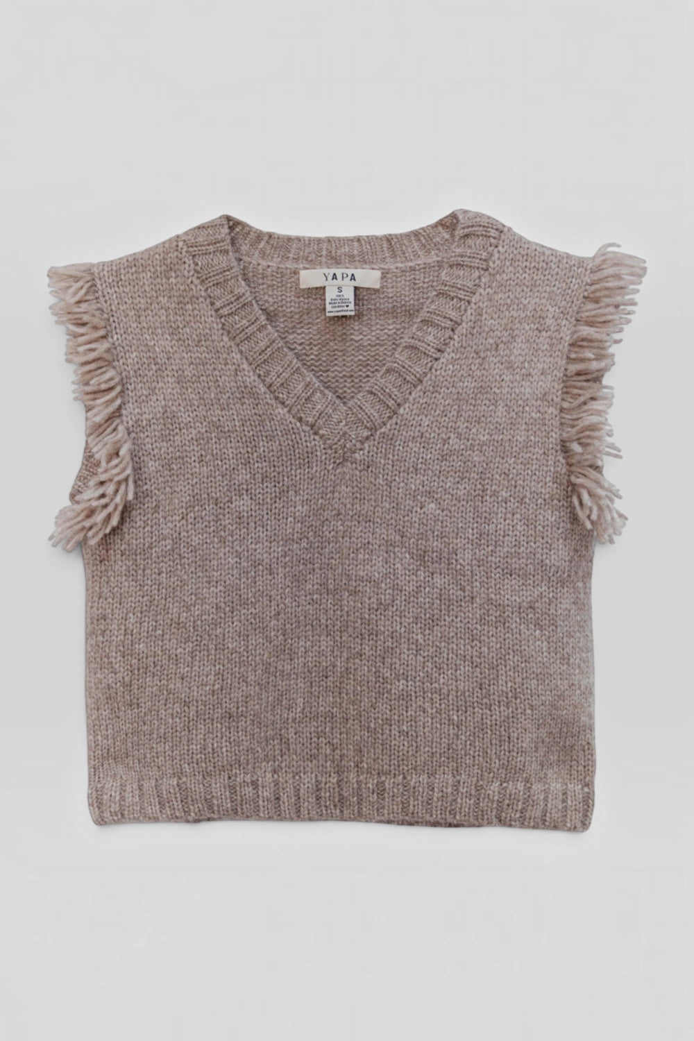 A sleeveless knit sweater vest in a heathered taupe-brown color, featuring a V-neckline and fringed trim along the shoulders and hem, laid flat against a light gray background.