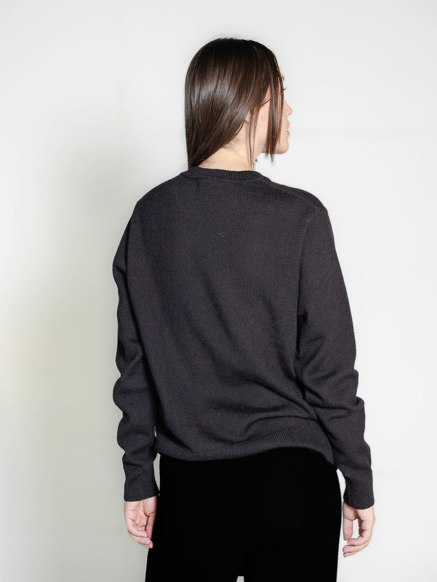 black alpaca knitted sweater with white llama design, worn by a model backwards on a white background