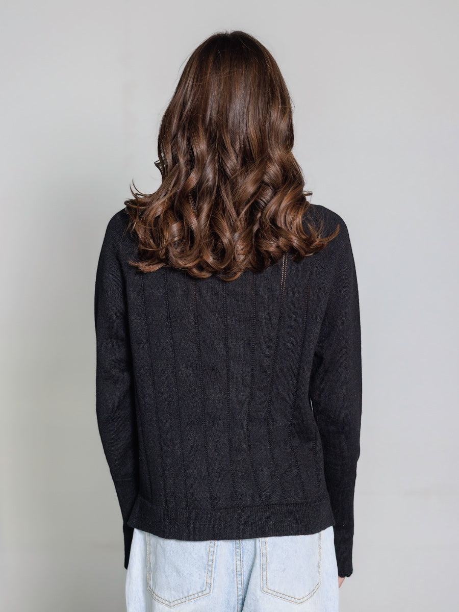 Model wearing a black hand embroidered  sweater with 'New York' text and skyline on a plain background