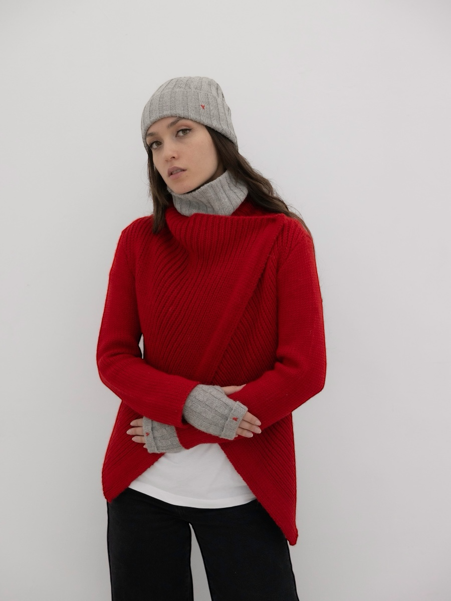chunky red alpaca knitted cardigan with unique crossed design, worn by a model styled with grey yapa beanie and fingerless grey gloves