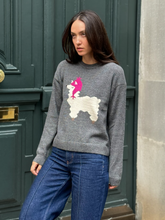 Load image into Gallery viewer, Woman wearing a gray sweater with a llama design, standing against a green door.
