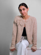 Cargar imagen en el visor de la galería, Woman wearing a beige knitted jacket with a large flower. Fall cardigans alpaca wool
