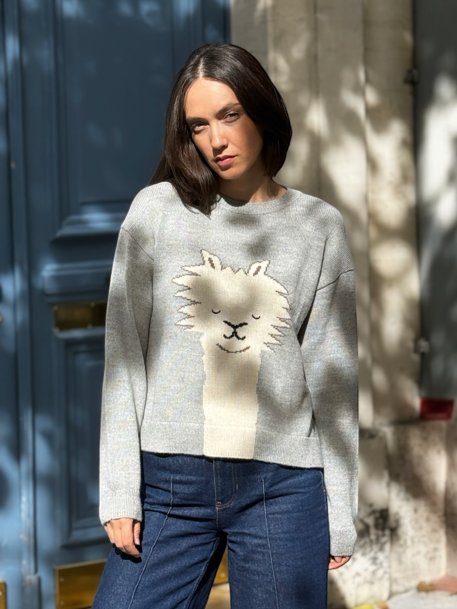 light grey alpaca knitted sweater with an alpaca face design, worn by a model against a neutral background