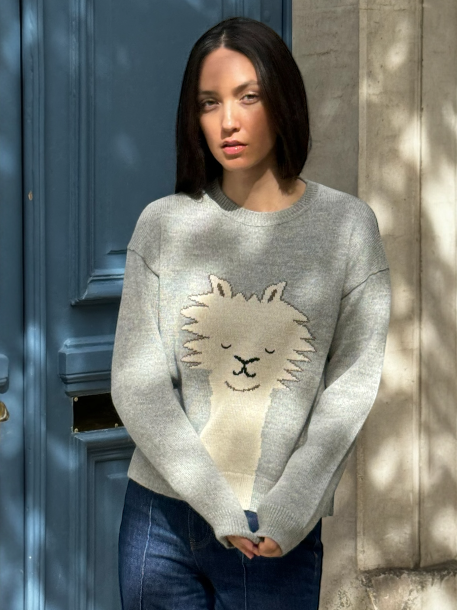 light grey alpaca knitted sweater with an alpaca face design, worn by a model against a neutral background