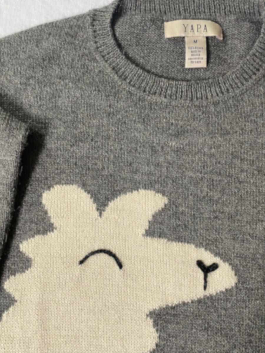 Close up of grey baby alpaca sweater made by artisans in Bolivia featuring a playful oversized white llama