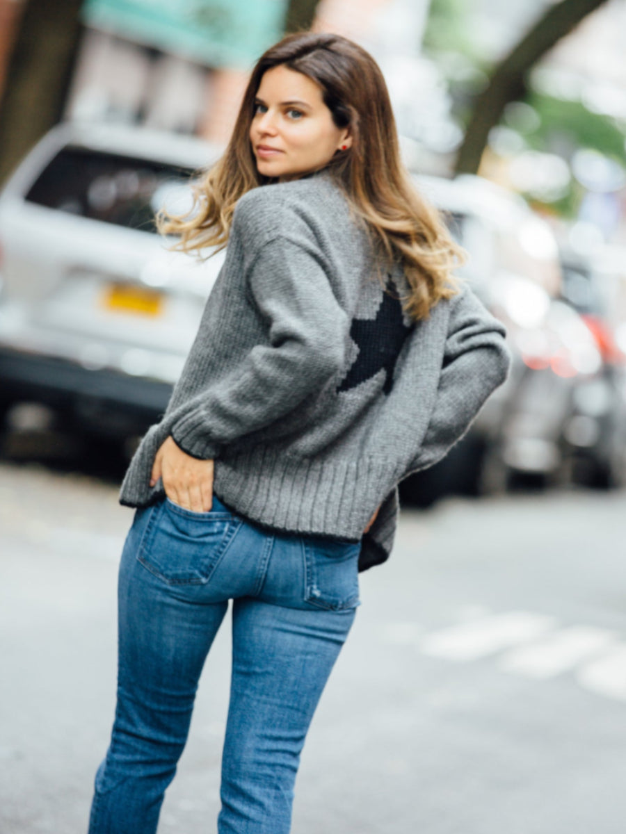 Grey alpaca sweater featuring a large black star motif on the back, shown here on a model 