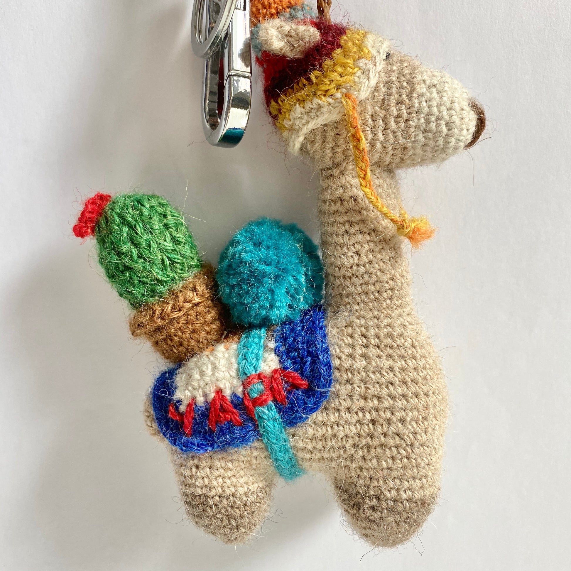 Handmade crochet alpaca keychain and bag charm with colorful details.