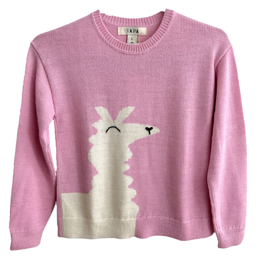 A girl wearing a pink crewneck sweater with an alpaca design and hand embroidered details, standing outdoors with a clear blue sky in the background.