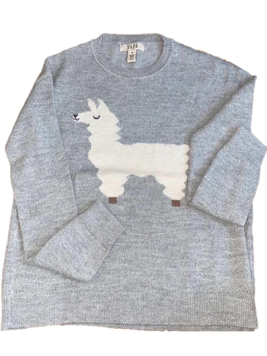 light grey alpaca knitted sweater with white llama design, worn by a model outdoors